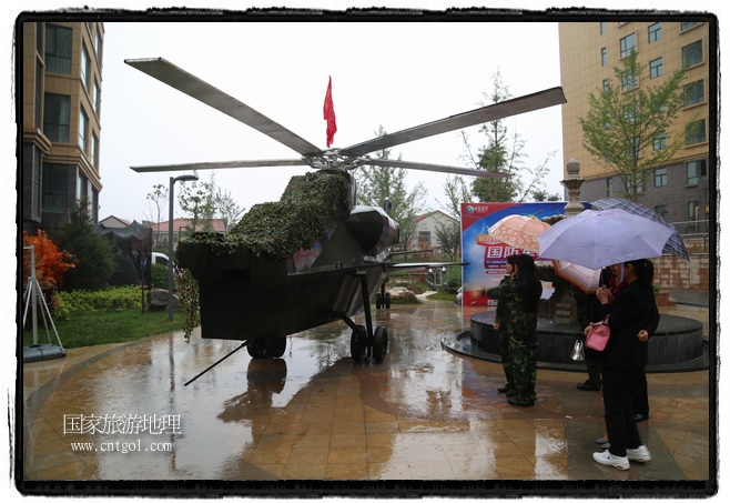 小區(qū)突然出現(xiàn)“飛機(jī)坦克”，其中殲15艦載戰(zhàn)斗機(jī)一架、99式主戰(zhàn)坦克一輛、武直-10武裝直升機(jī)一架，吸引了眾多市民雨中圍觀、合影。